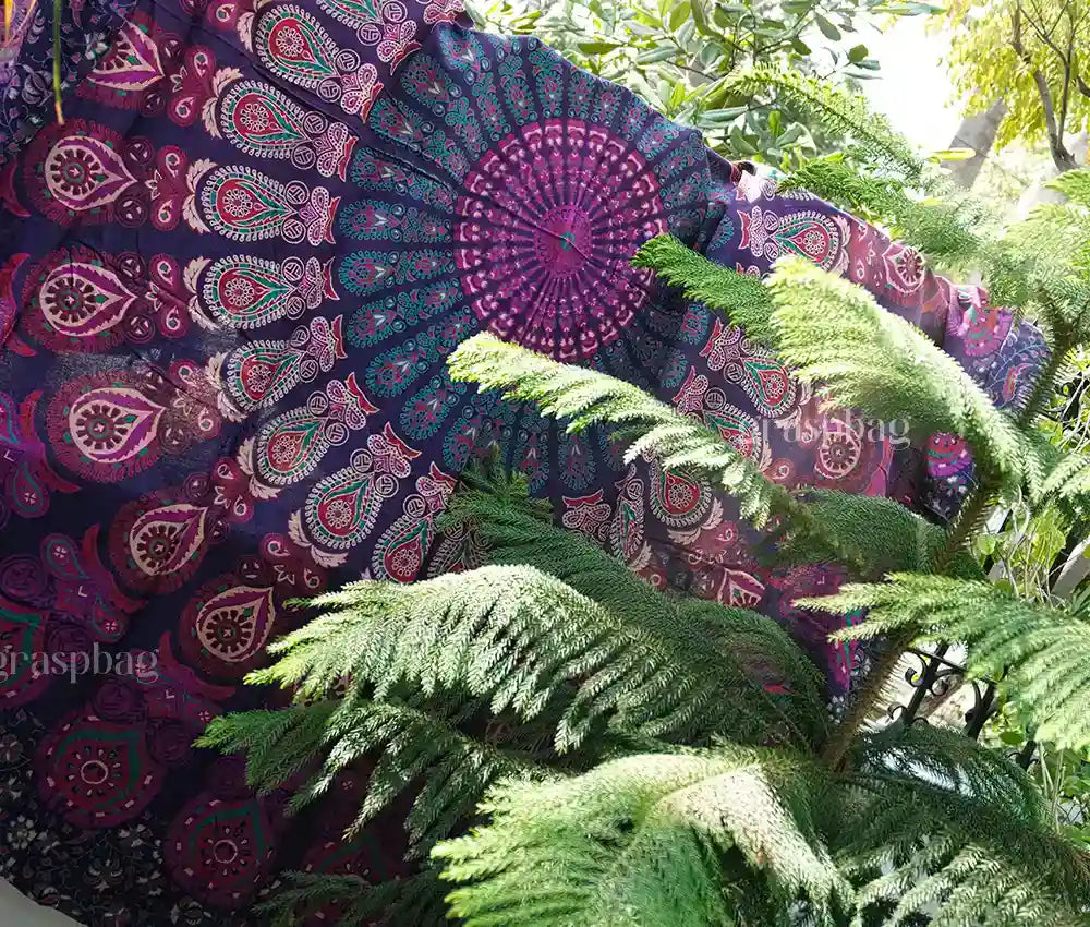 Round pink mandala tapestry used as boho tablecloth, chair throw, or beach mat